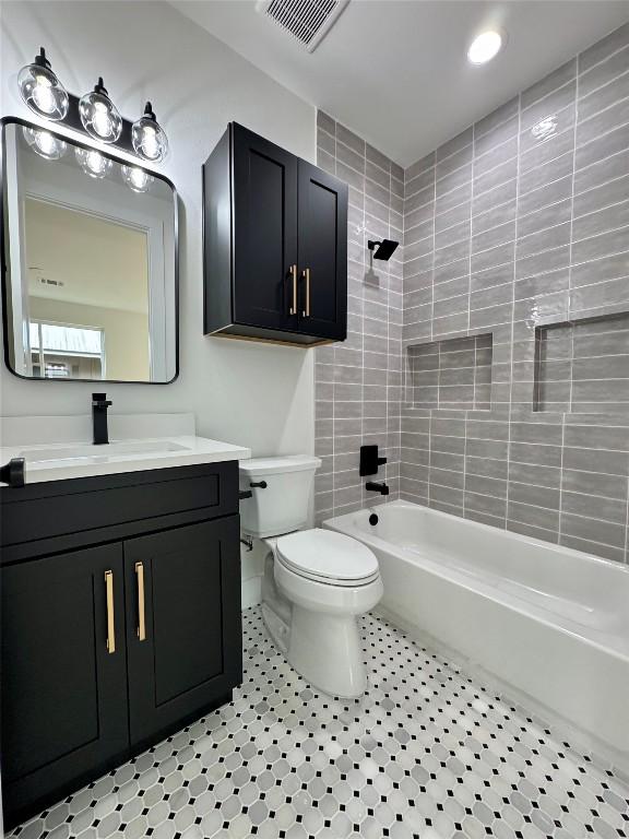 1708 Canterbury St Unit 1, Austin, TX 78702 - bathroom with toilet, vanity, washtub / shower combination, and tile patterned flooring
