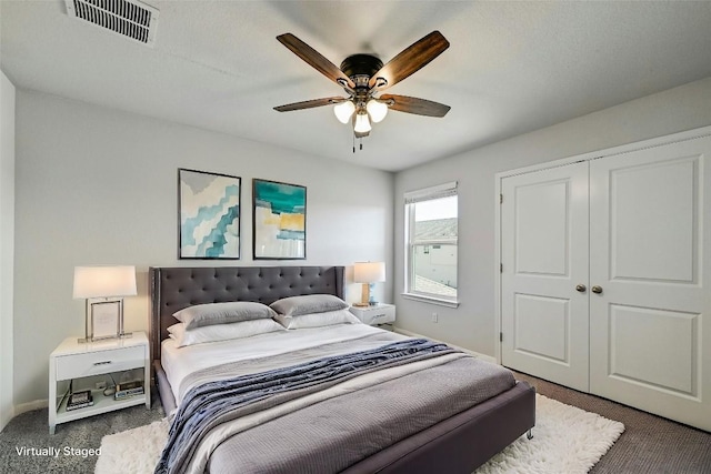 bedroom with ceiling fan, a closet, and dark colored carpet