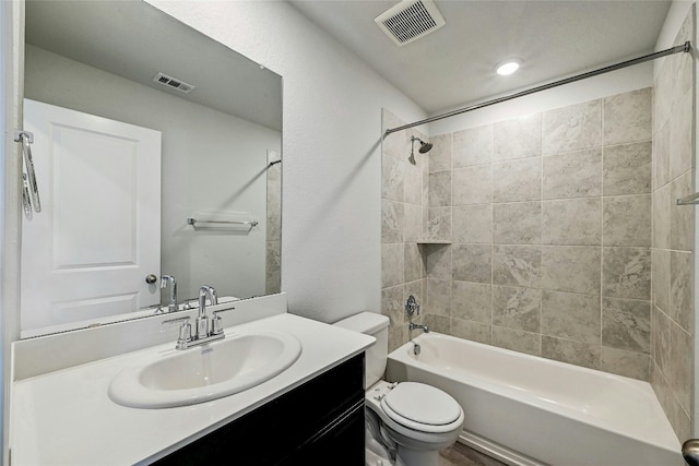 full bathroom with vanity, tiled shower / bath combo, and toilet