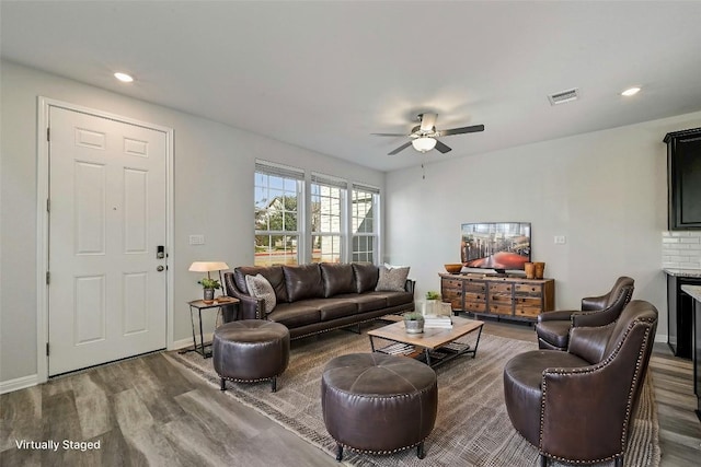 living room with wood-type flooring and ceiling fan