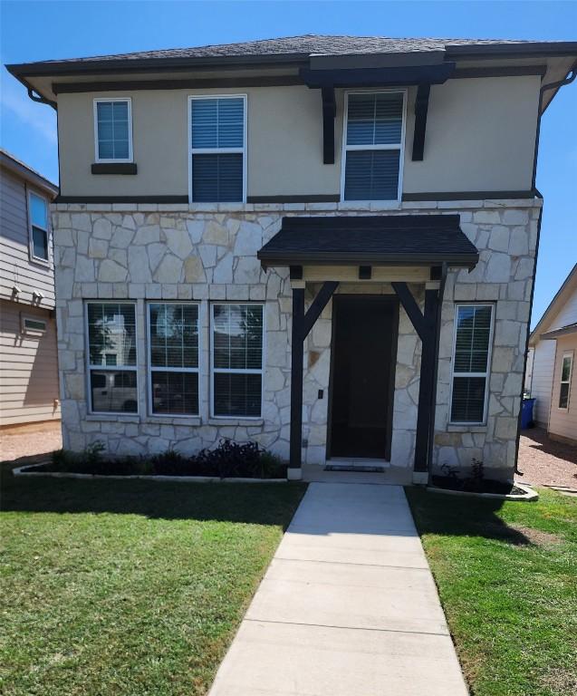 182 Mckittrick Ridge St, Dripping Springs, TX 78620 - view of front of home with stone siding, a front yard, and stucco siding