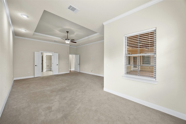 unfurnished room with a raised ceiling, ornamental molding, carpet floors, and ceiling fan