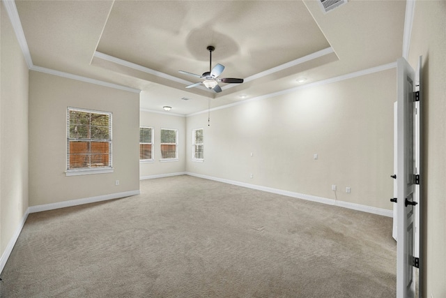 carpeted empty room featuring ornamental molding, ceiling fan, and a tray ceiling