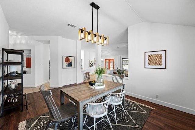 dining room featuring lofted ceiling and dark hardwood / wood-style floors