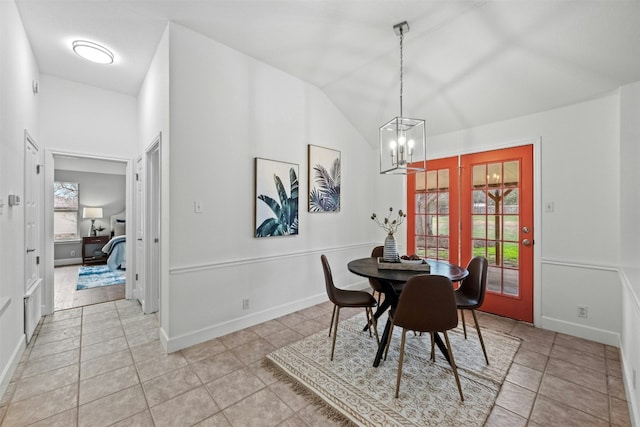 tiled dining room featuring lofted ceiling and a chandelier