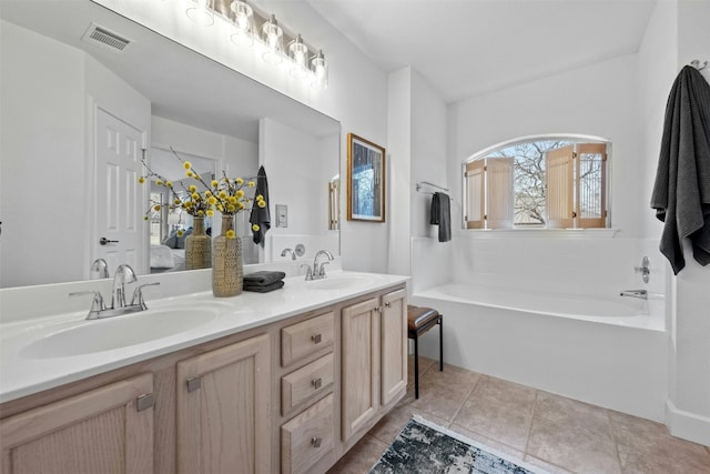 bathroom featuring vanity, a tub, and tile patterned floors