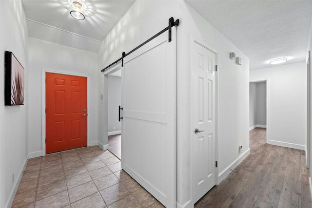 entryway with a barn door and light tile patterned floors