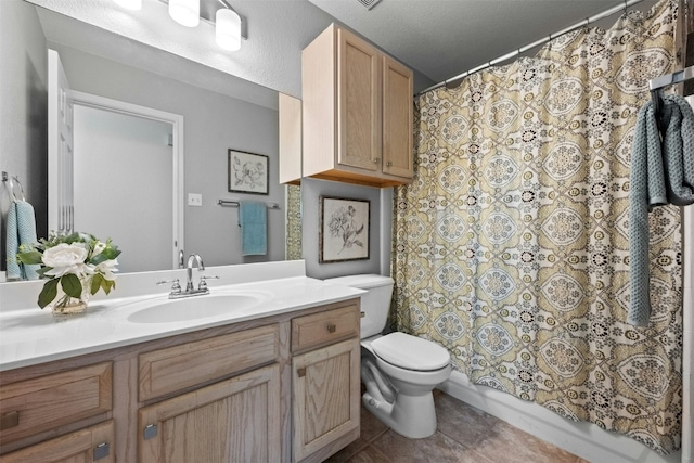 bathroom with tile patterned flooring, vanity, and toilet