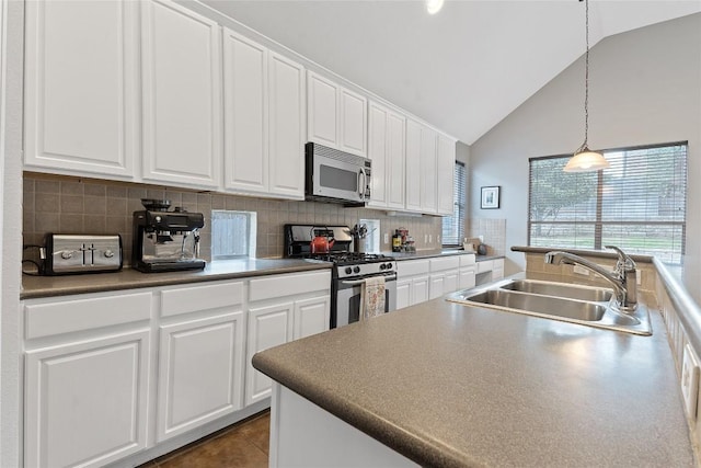 kitchen featuring sink, tasteful backsplash, decorative light fixtures, appliances with stainless steel finishes, and white cabinets