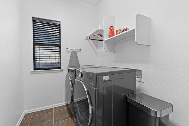 laundry area featuring washer and dryer and dark tile patterned floors