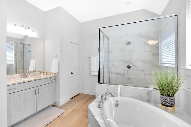 bathroom featuring hardwood / wood-style flooring, vanity, separate shower and tub, and lofted ceiling