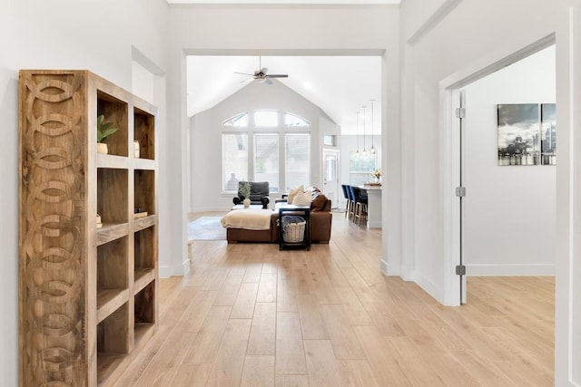 interior space featuring ceiling fan, lofted ceiling, and light hardwood / wood-style floors