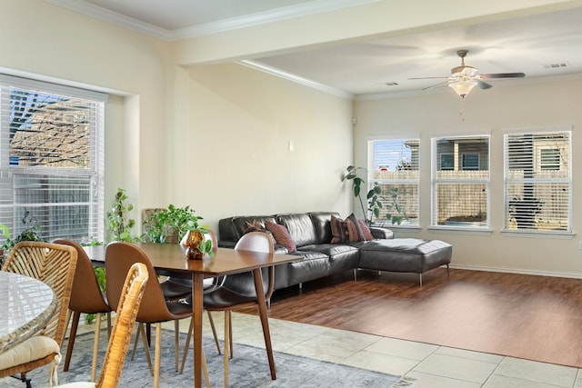 tiled dining room featuring crown molding and ceiling fan