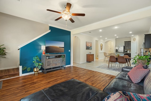 living room featuring ornamental molding, light hardwood / wood-style floors, and ceiling fan