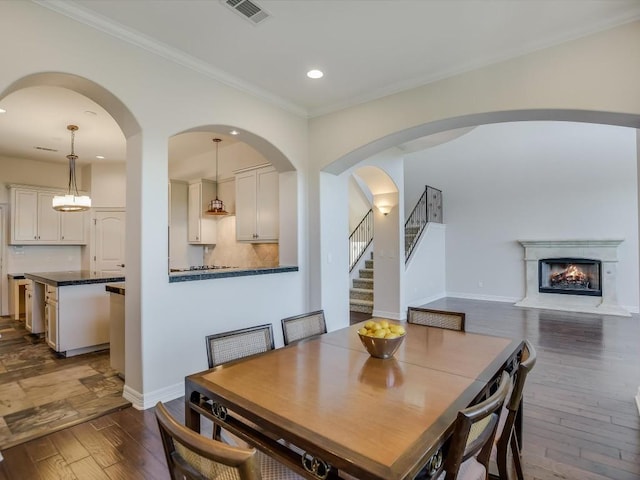 dining space with ornamental molding and dark wood-type flooring