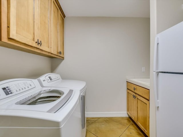 laundry room with light tile patterned flooring, cabinets, and separate washer and dryer