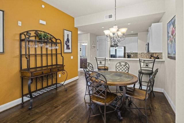 dining area with an inviting chandelier and dark hardwood / wood-style floors