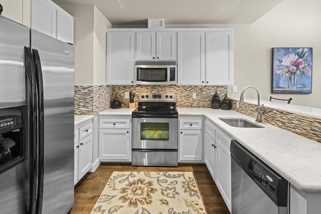 kitchen featuring sink, white cabinetry, backsplash, stainless steel appliances, and dark hardwood / wood-style flooring