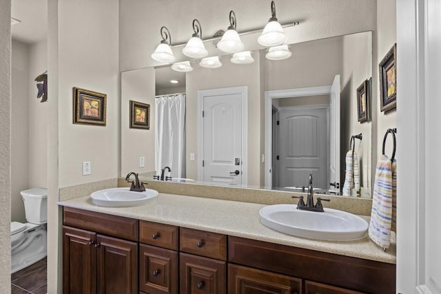 bathroom with vanity, tile patterned flooring, and toilet