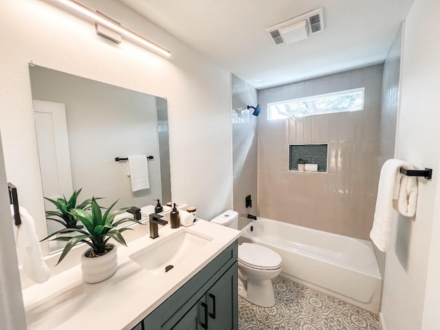 full bathroom featuring vanity, toilet, tiled shower / bath combo, and tile patterned flooring