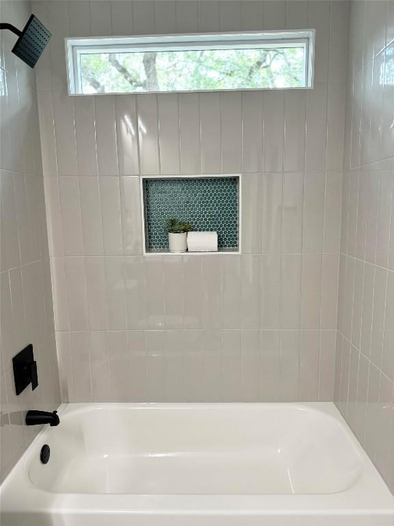 bathroom with tiled shower / bath and a healthy amount of sunlight