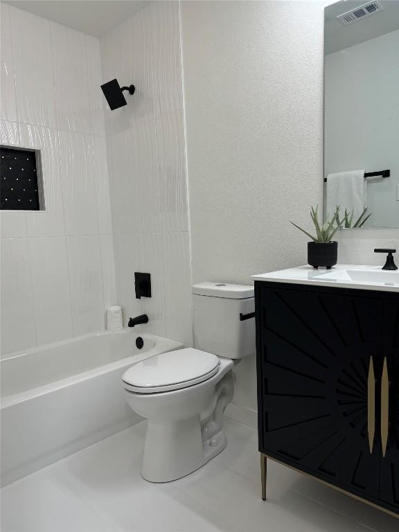 full bathroom with tiled shower / bath, vanity, toilet, and tile patterned flooring