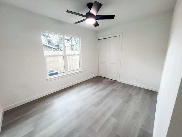 unfurnished bedroom with light hardwood / wood-style floors, a closet, and ceiling fan