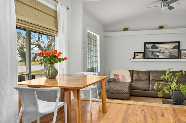 dining area featuring a healthy amount of sunlight, vaulted ceiling, and light hardwood / wood-style floors