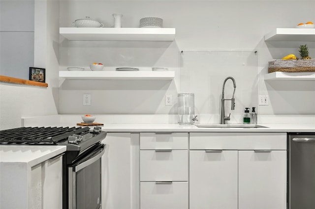 kitchen featuring sink, white cabinetry, and gas stove