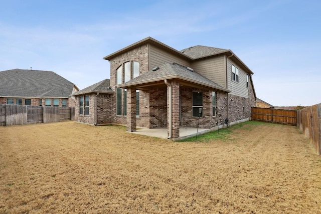 back of house with a patio, brick siding, a shingled roof, and a fenced backyard