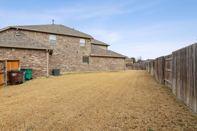 back of property featuring a yard and central AC