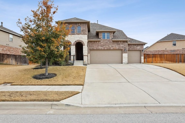 view of front of house featuring brick siding, a shingled roof, fence, stone siding, and driveway