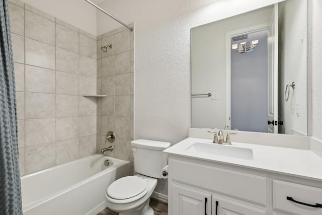 full bathroom featuring a textured wall, shower / tub combo, vanity, and toilet