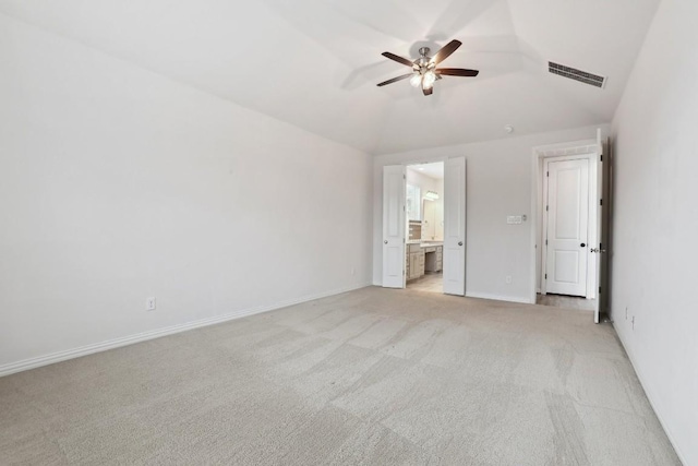 spare room featuring visible vents, a ceiling fan, light carpet, vaulted ceiling, and baseboards