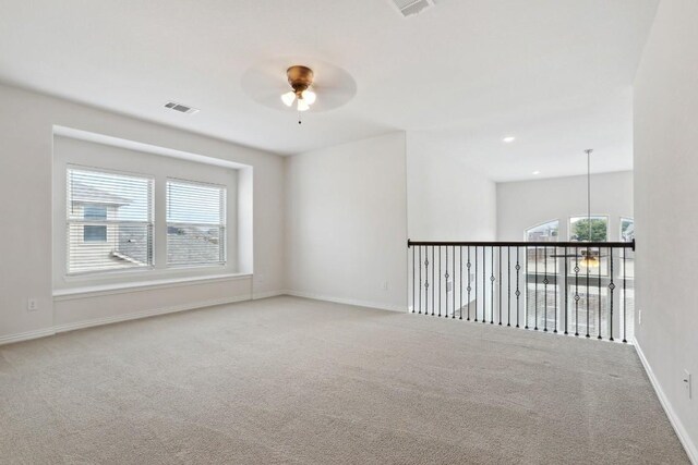 carpeted empty room featuring ceiling fan and plenty of natural light