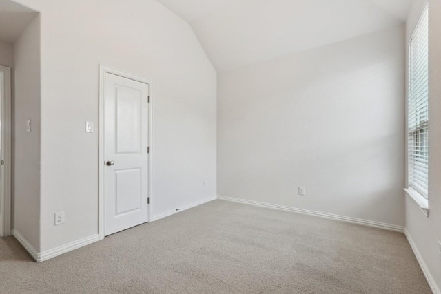 spare room with lofted ceiling, baseboards, and carpet floors