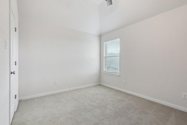 unfurnished room featuring vaulted ceiling and light colored carpet