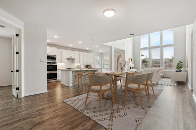 dining room with dark wood-style flooring, recessed lighting, visible vents, and baseboards