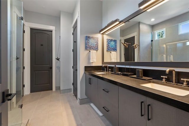 bathroom with tile patterned floors, vanity, and a tile shower