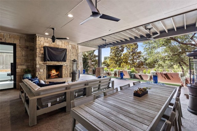 view of patio / terrace with ceiling fan and an outdoor stone fireplace