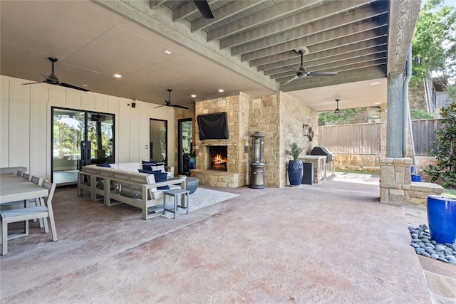 view of patio featuring ceiling fan and an outdoor stone fireplace