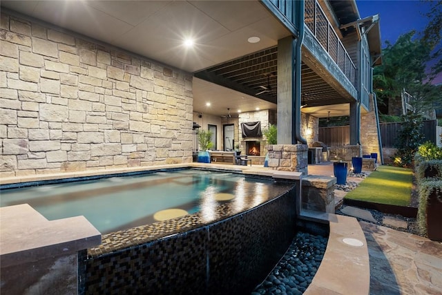 view of pool with a patio area and an outdoor stone fireplace