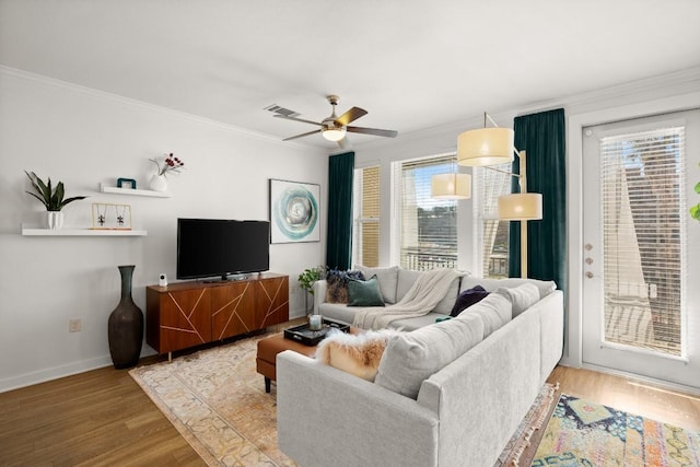 living room featuring hardwood / wood-style flooring, ornamental molding, and ceiling fan