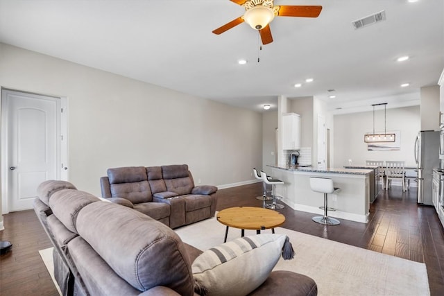 living room with dark hardwood / wood-style floors and ceiling fan