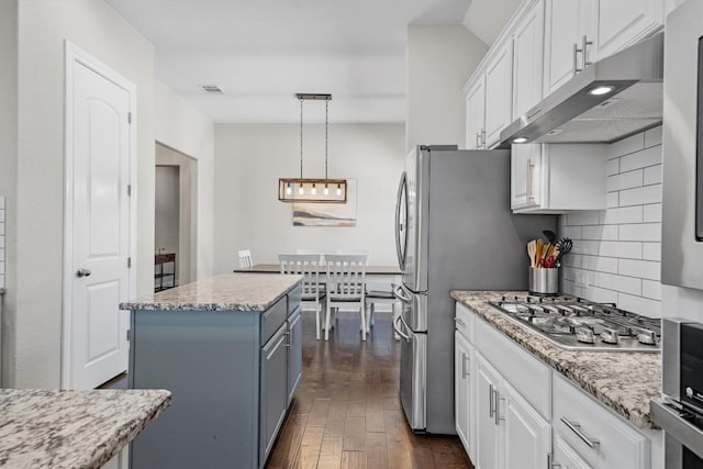 kitchen featuring hanging light fixtures, a center island, white cabinets, and stainless steel gas cooktop