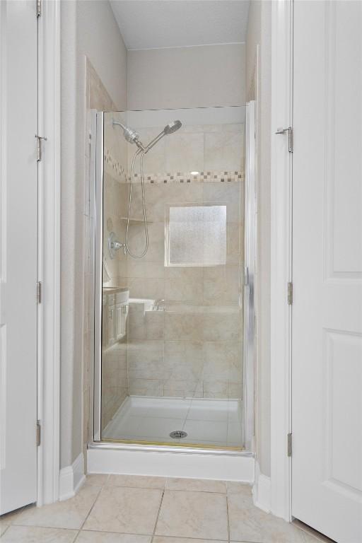 bathroom with tile patterned flooring and a shower with door