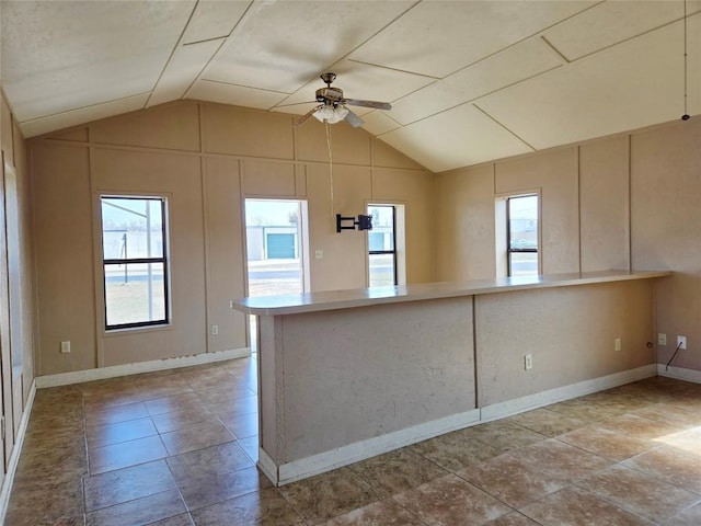 kitchen featuring ceiling fan, kitchen peninsula, and vaulted ceiling