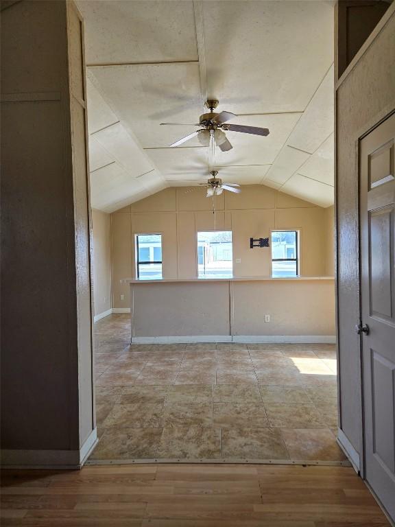 unfurnished room with lofted ceiling, light hardwood / wood-style flooring, and ceiling fan