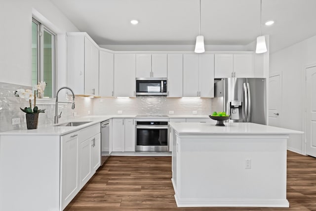 kitchen featuring white cabinetry, sink, decorative light fixtures, and appliances with stainless steel finishes