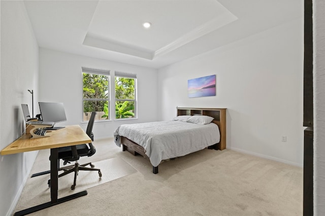 bedroom with a tray ceiling and light colored carpet